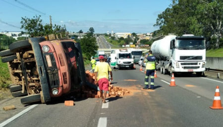 Caminhão tomba carregado de tijolos na rodovia SP-101; carga ficou espalhada
