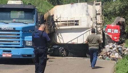 Mulher morre após caminhão de lixo tombar sobre seu carro