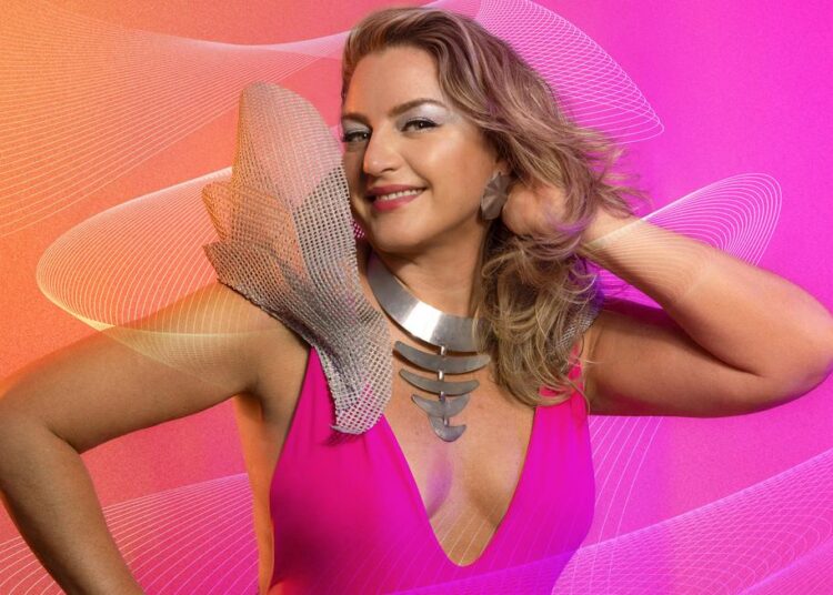 Cantora Maíra Guedes com microfone durante lançamento musical