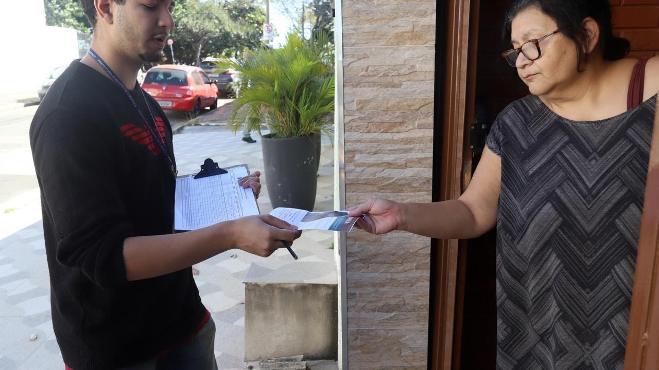 Agentes conversam com moradores e entregam folhetos informativos sobre prevenção da raiva no entorno do Cemitério da Saudade