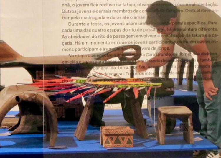 Bancos rituais de madeira esculpidos e máscaras indígenas usadas em cerimônias tradicionais