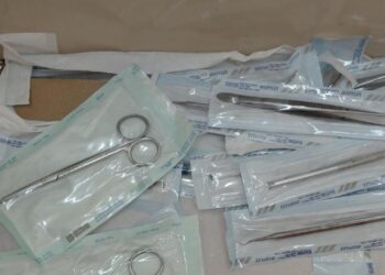 Seringa descartável reprocessada, pia com resíduos e materiais com sujidades