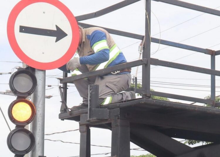 Sinalização viária nova na rua e agentes da Mobilidade Urbana monitorando circulação