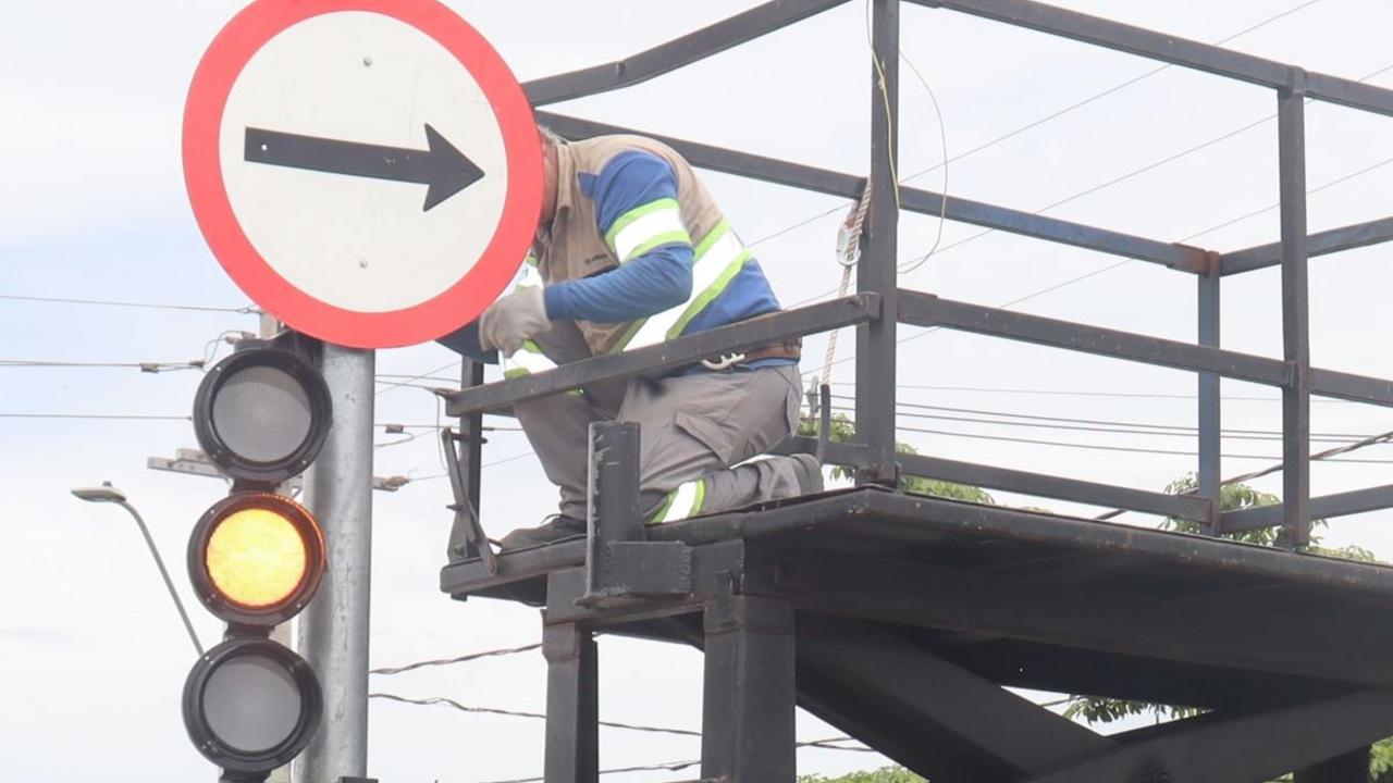 Sinalização viária nova na rua e agentes da Mobilidade Urbana monitorando circulação