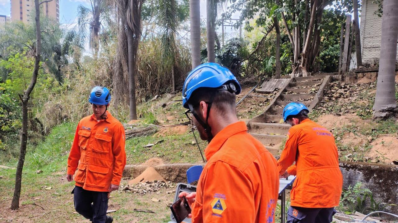 Agentes da Defesa Civil com cão robô e drone em área de demolição