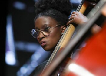 Orquestra com jovens instrumentistas entre 18 e 27 anos em apresentação musical