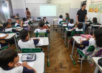 Profissional conversa com equipe escolar durante visita para fortalecer vínculos