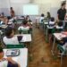 Profissional conversa com equipe escolar durante visita para fortalecer vínculos