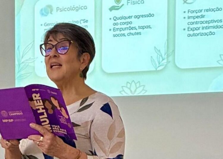 Psicóloga Leila Rocha utilizando a cartilha de orientação sobre violência contra a mulher