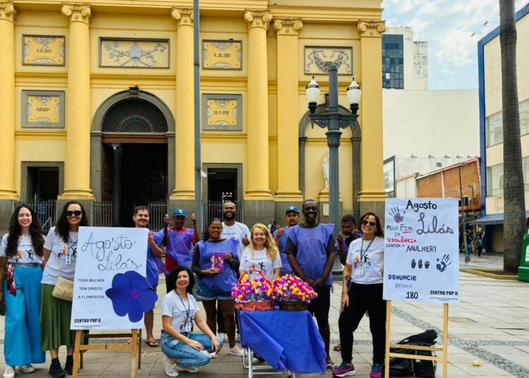 Pessoas atendidas pelo Centro POP Sares II orientando sobre violência contra mulher no Largo da Catedral