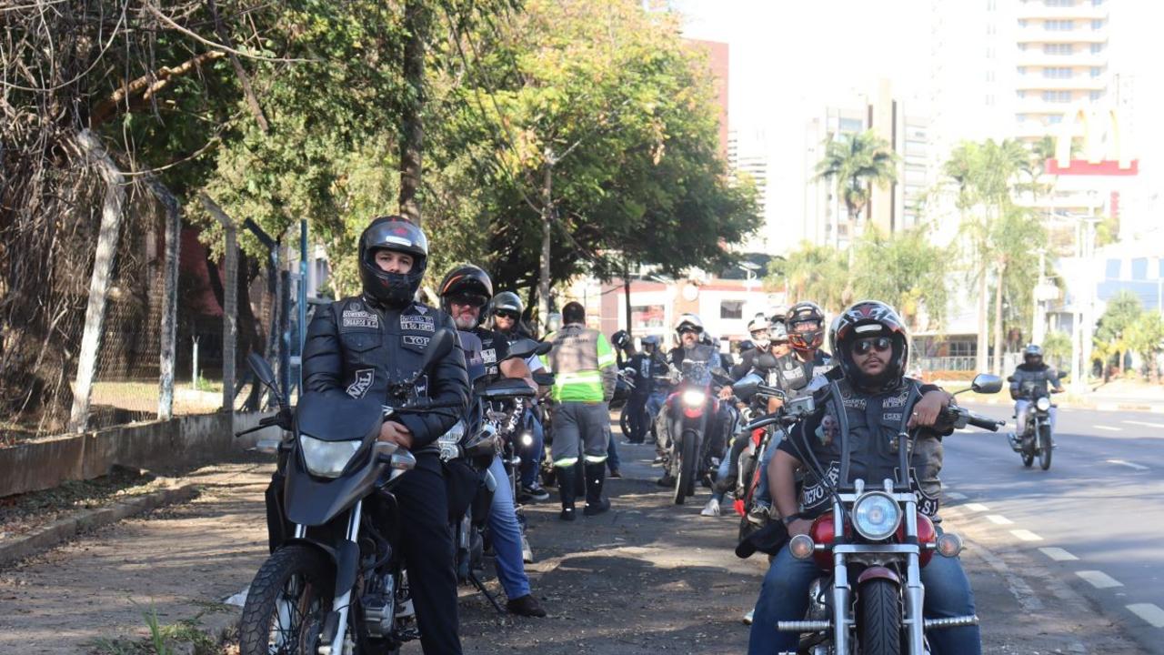 Motociclistas do grupo abordando condutores e distribuindo materiais educativos sobre trânsito