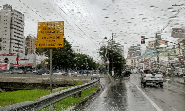 Vista da avenida Orosimbo Maia em dia chuvoso com veículos e proteção da Defesa Civil