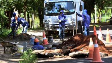 Equipes aumentando caixas para captar água da chuva durante obra de drenagem