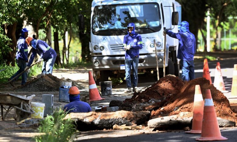 Equipes aumentando caixas para captar água da chuva durante obra de drenagem